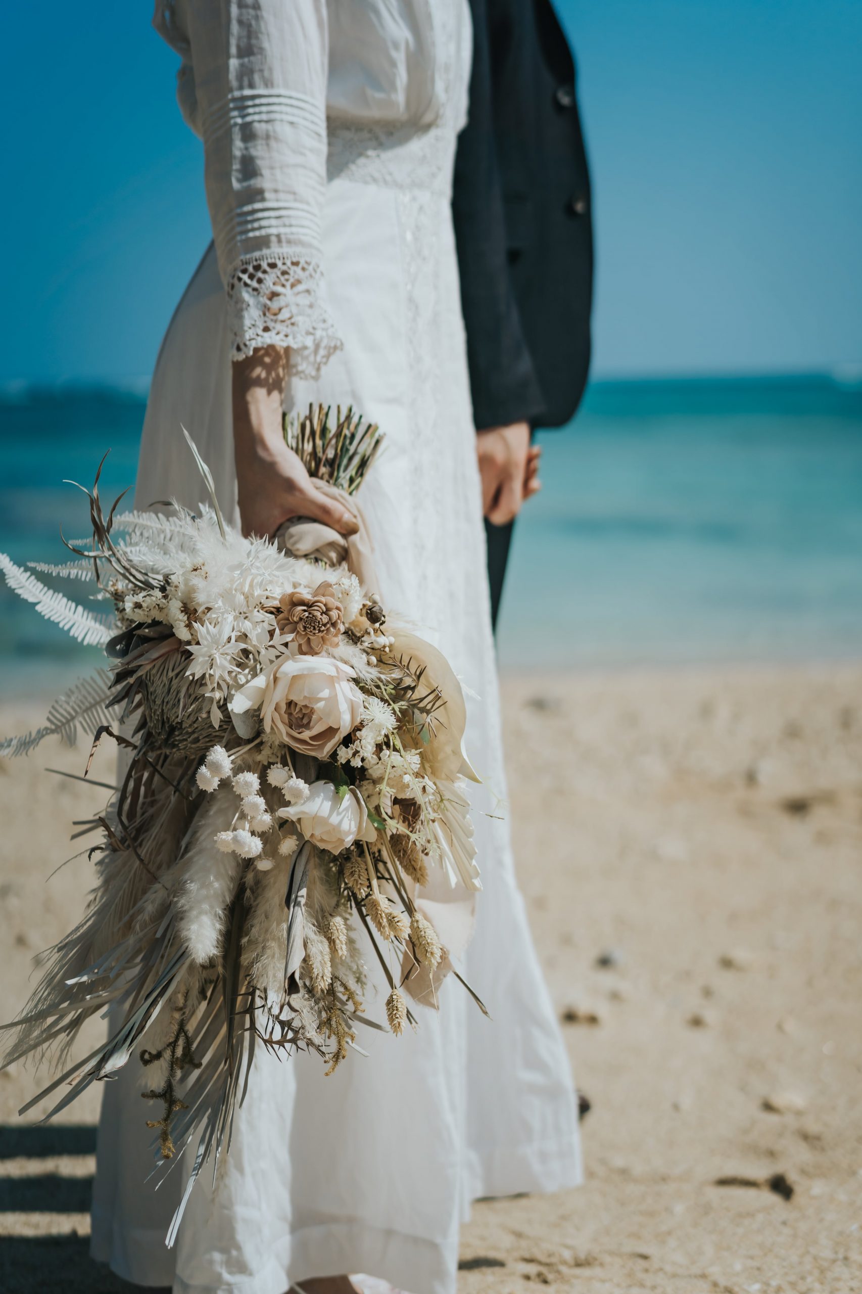 沖縄のフォトウェディングでの新郎新婦とドライフラワーブーケ