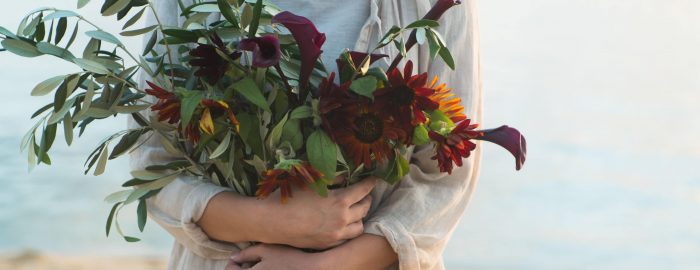 フレッシュな花を抱いた女性