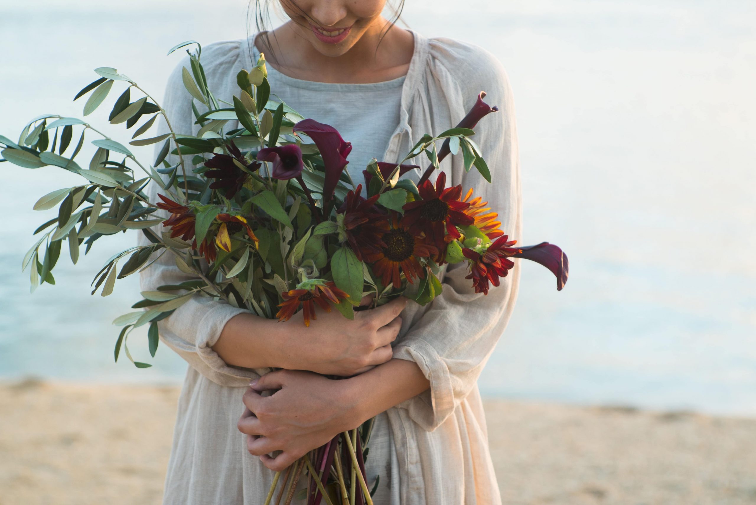 フレッシュな花を抱いた女性