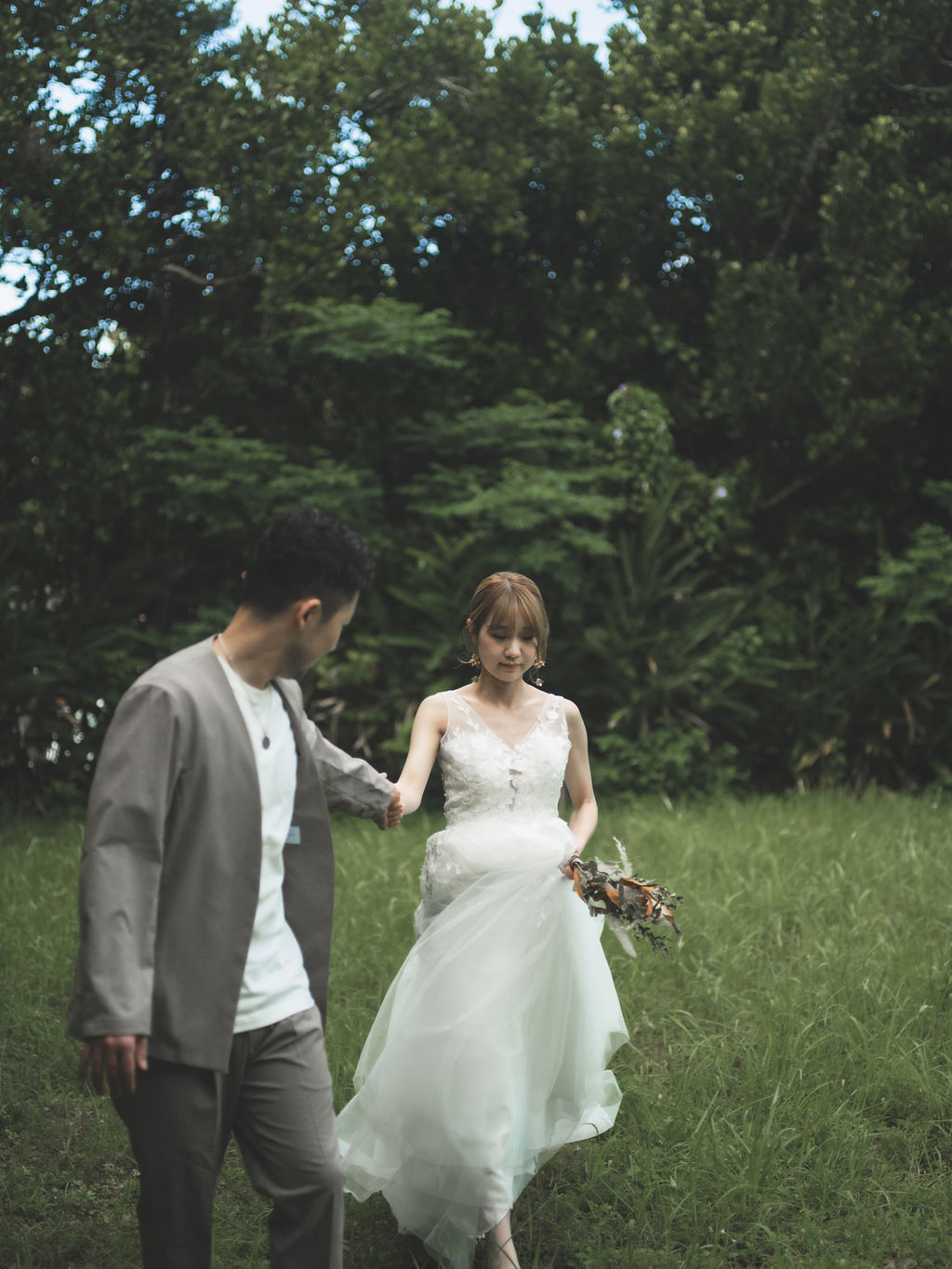 沖縄前撮りにてガーデンを歩く新郎新婦。