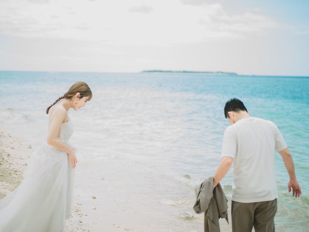沖縄前撮りでビーチ撮影をする新郎新婦。